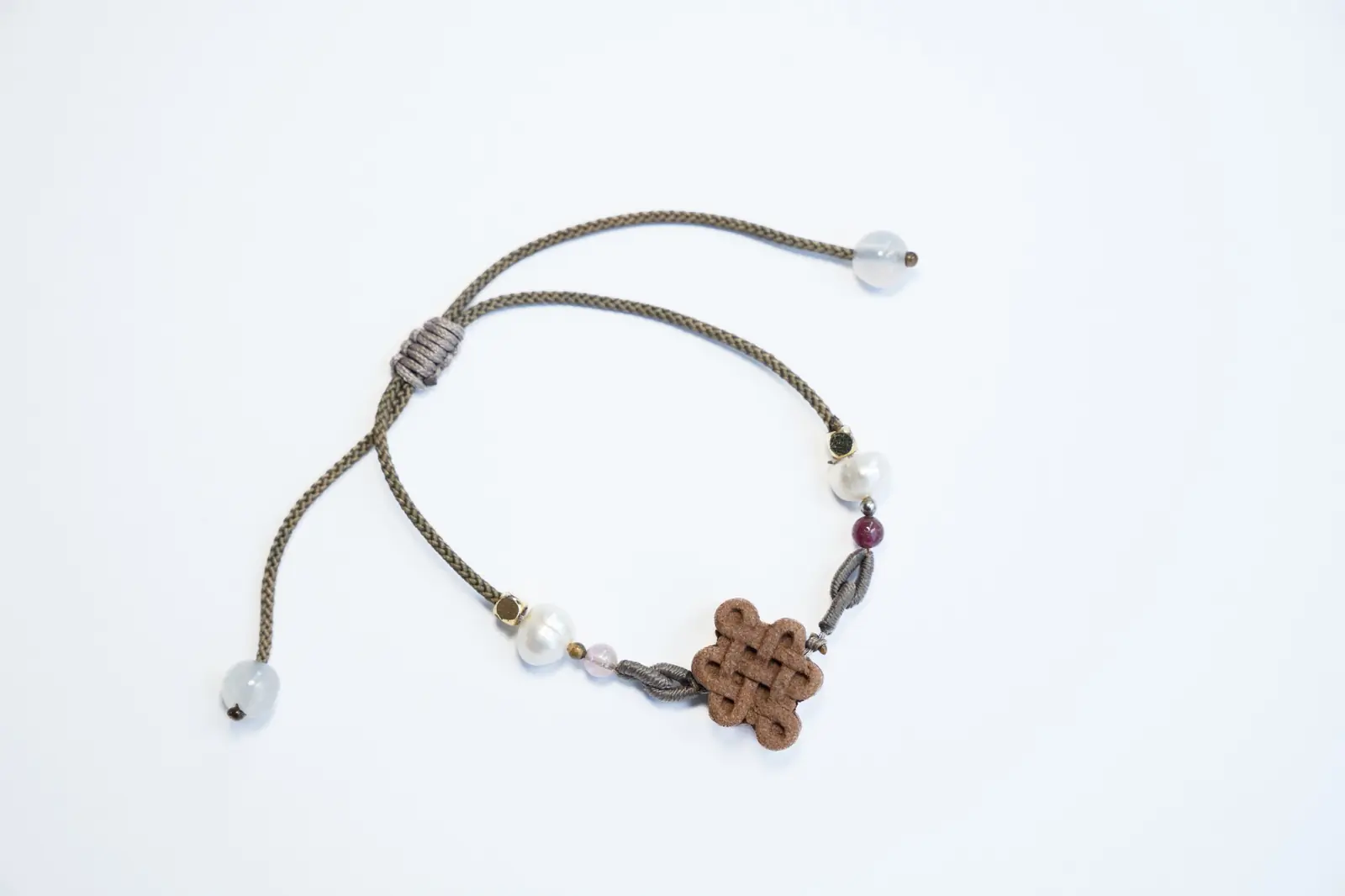 Taihe Xiangtang blended-incense bracelet laid flat with pearls, beads and an adjustable cord